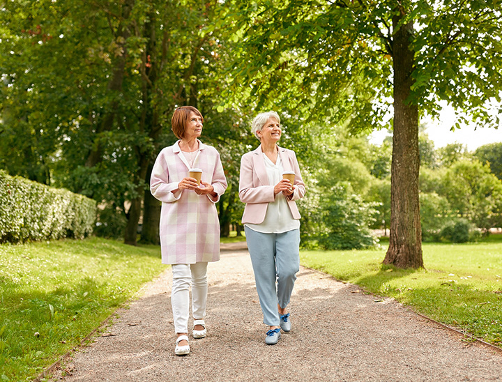 Image of two people walking on a pathway in a community open space.